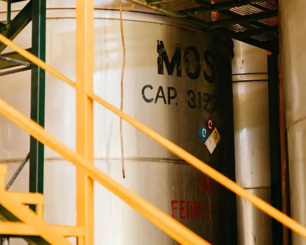 A conveyor belt with various debris, located indoors, surrounded by wooden elements