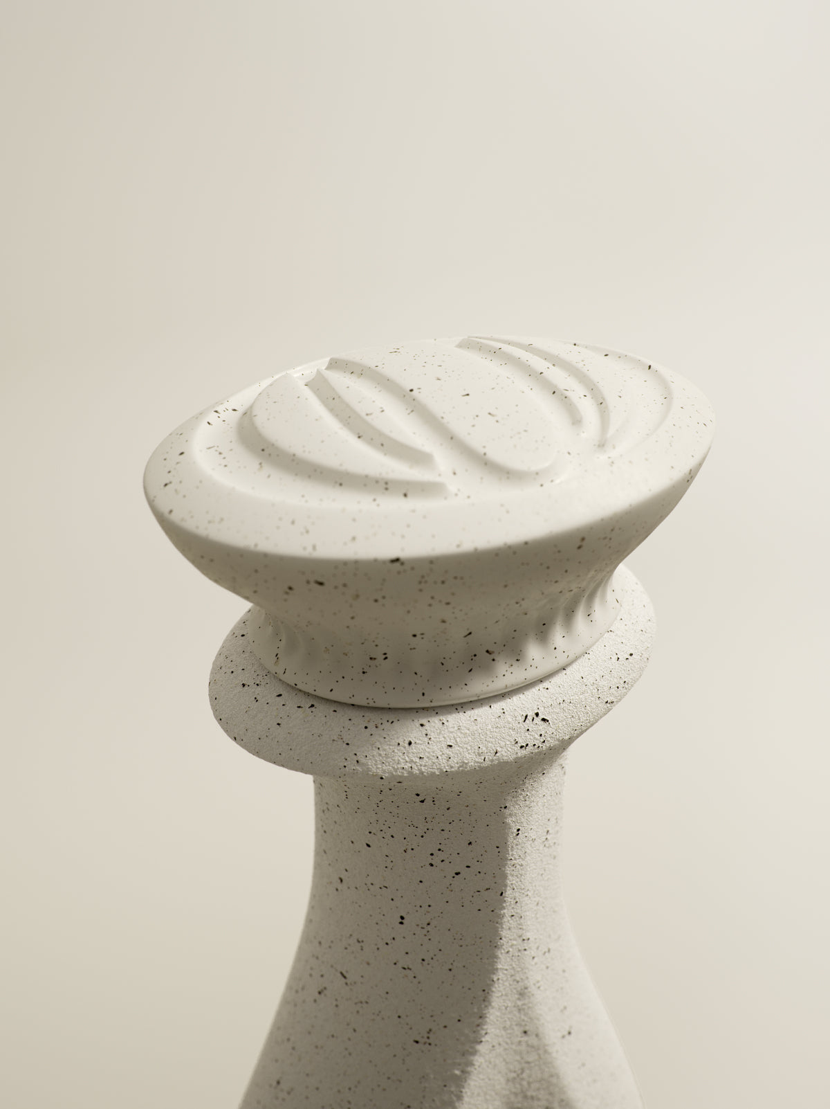 White ceramic Olujo knob with textured surface and ridges, set against a plain background