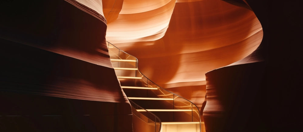 Spiraling staircase amidst smooth, curved rock formations with warm lighting